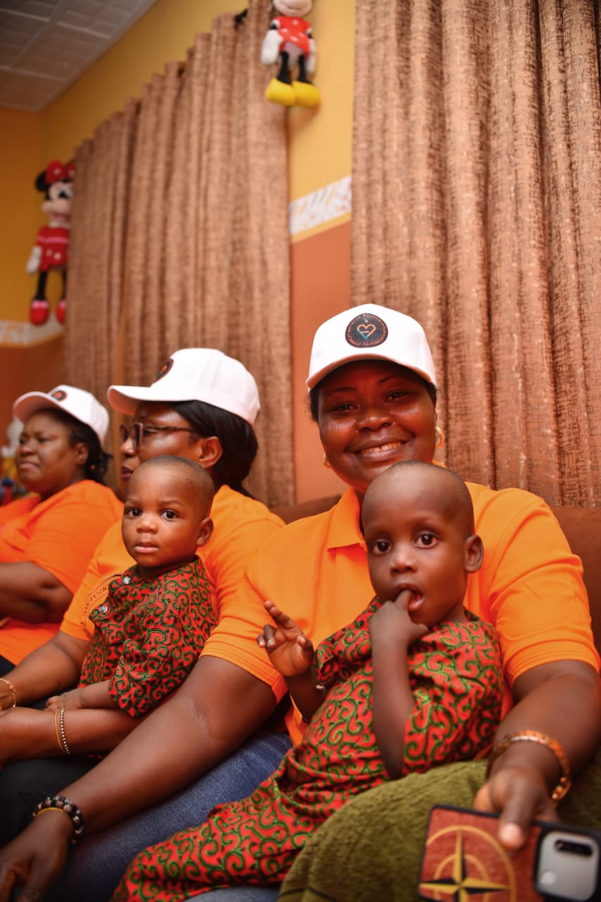 A LAOF volunteer seated with children during a visit