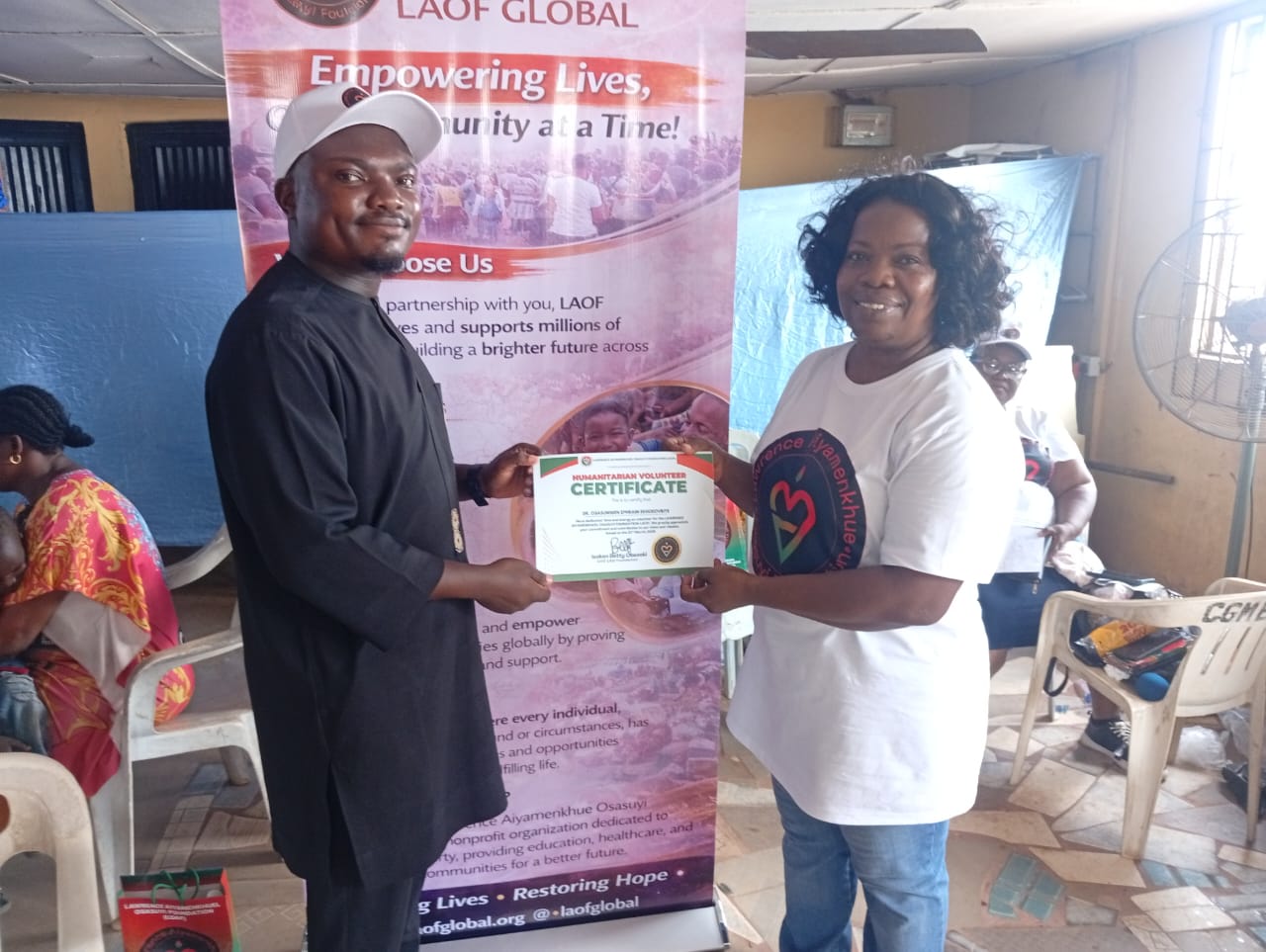 LAOF representatives presenting a document in front of an outreach banner