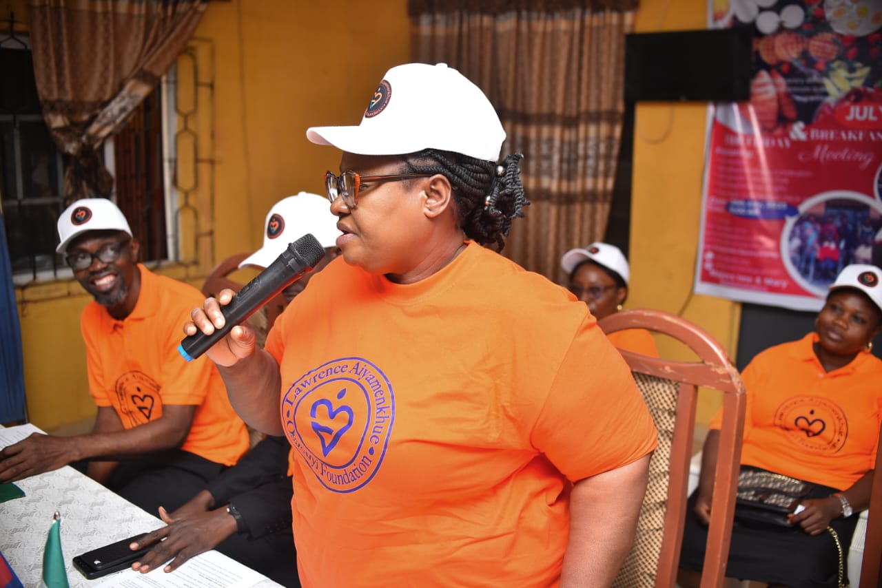 A LAOF volunteer addressing a gathering with a microphone