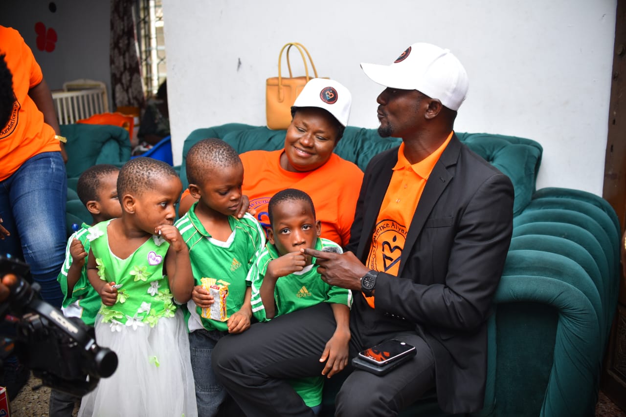 LAOF volunteers and children sharing a seat during a community visit