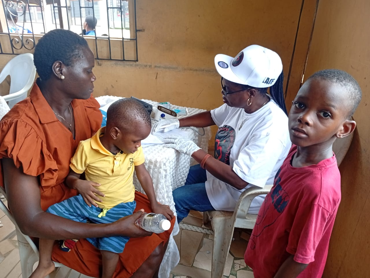 A LAOF volunteer attending to a mother and young child