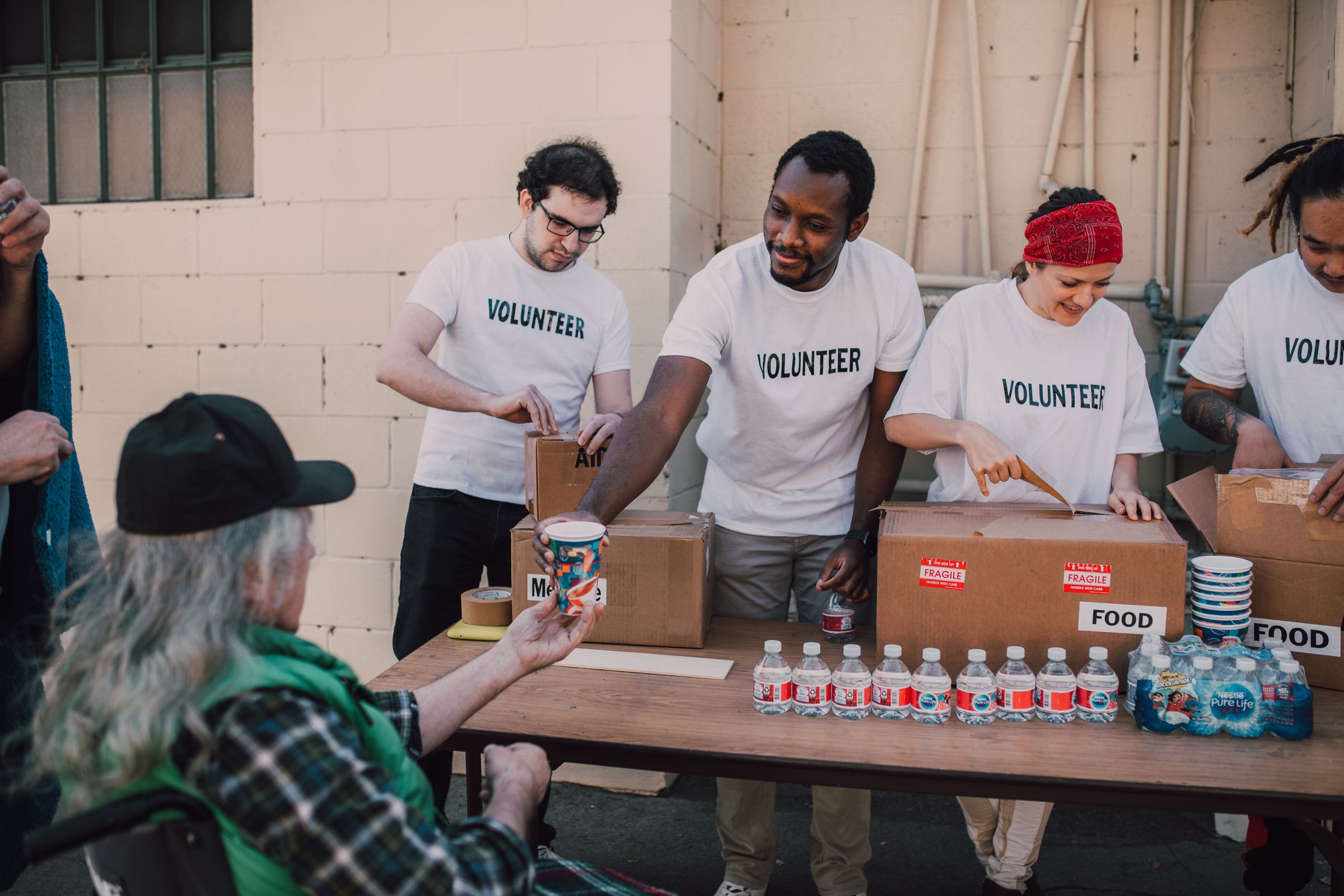 Illustrative photo: Volunteers distributing food at an outdoor donation table
