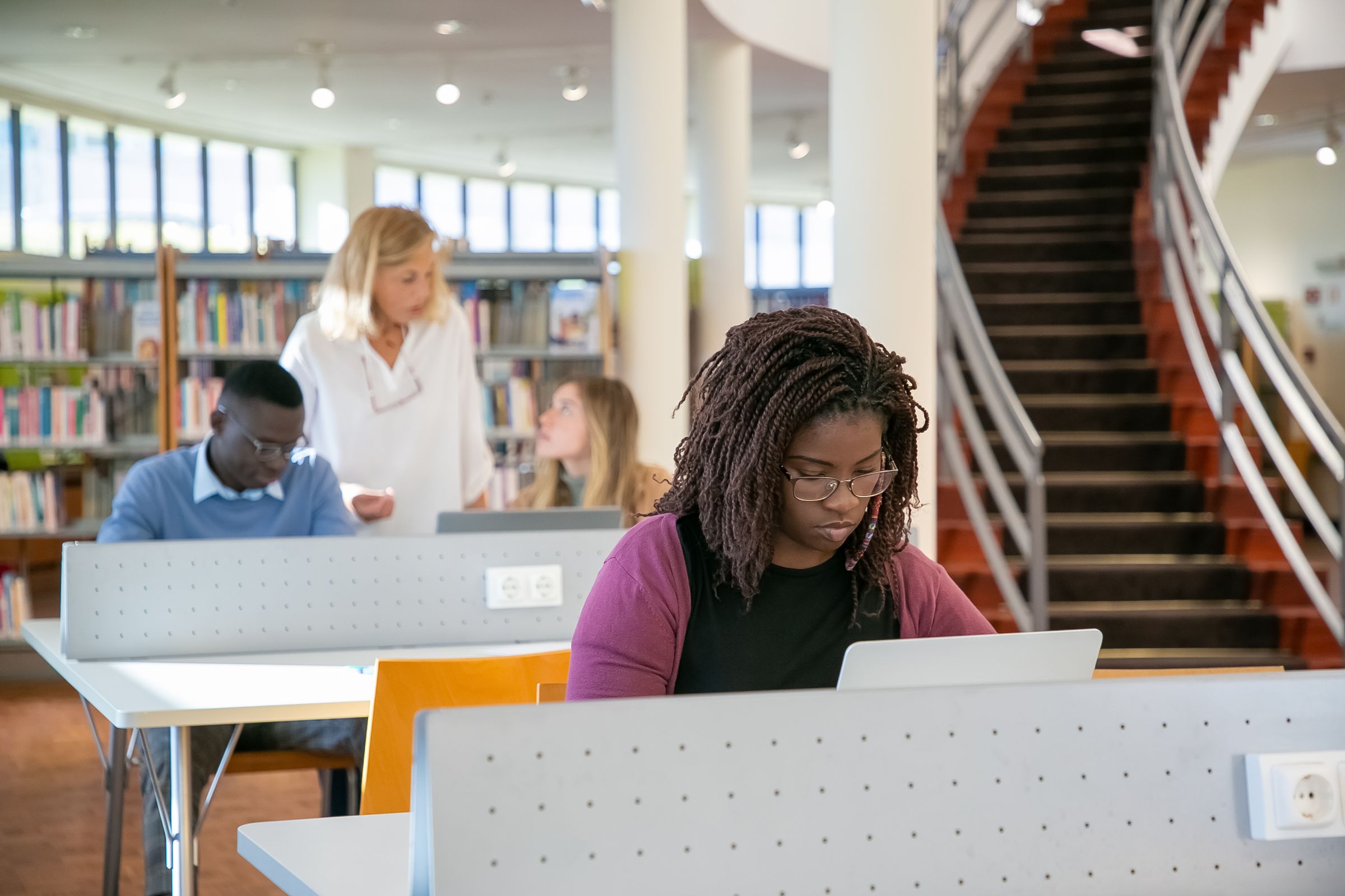 Illustrative photo: Students using laptops in a library