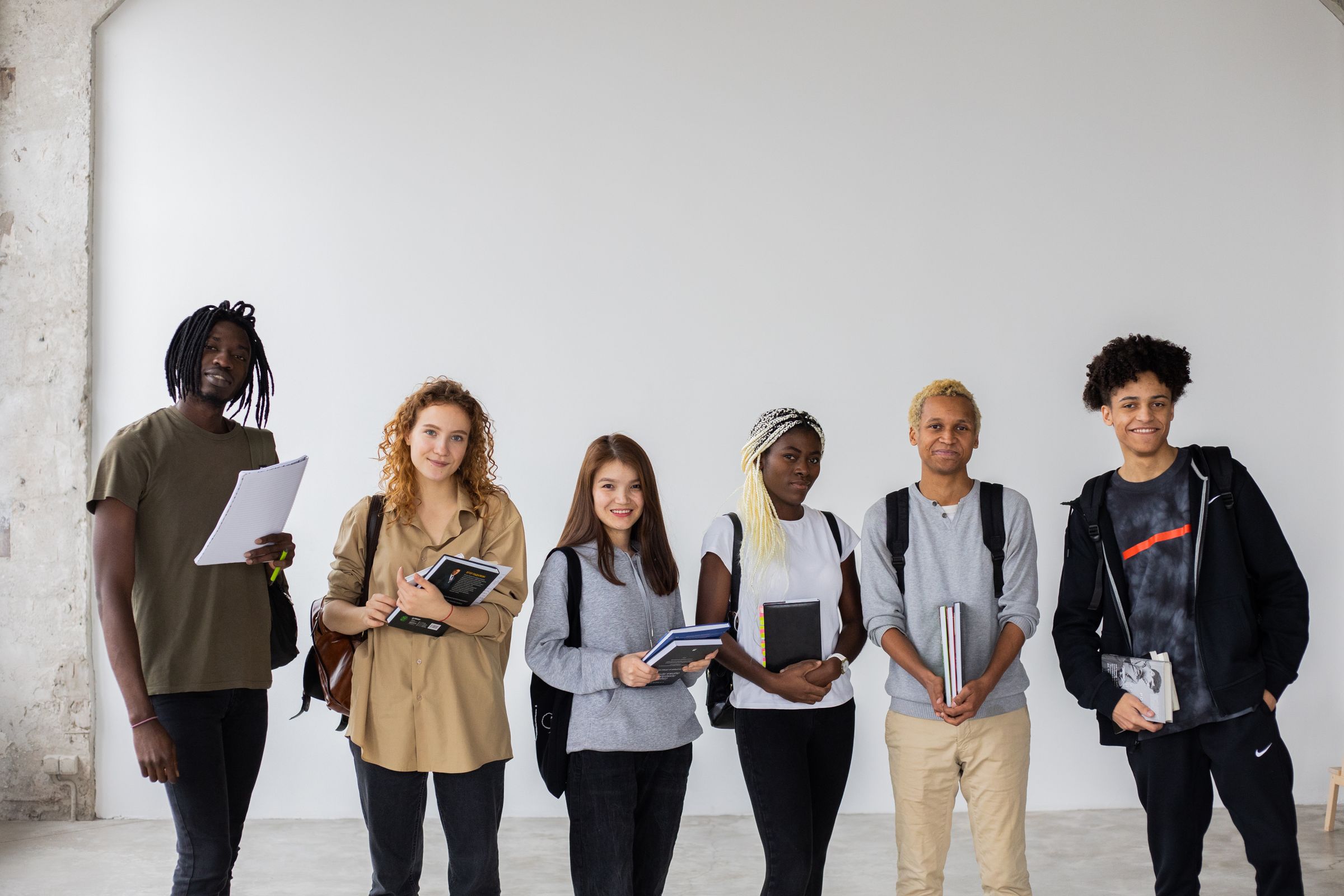 Illustrative photo: A group of students holding books and notebooks