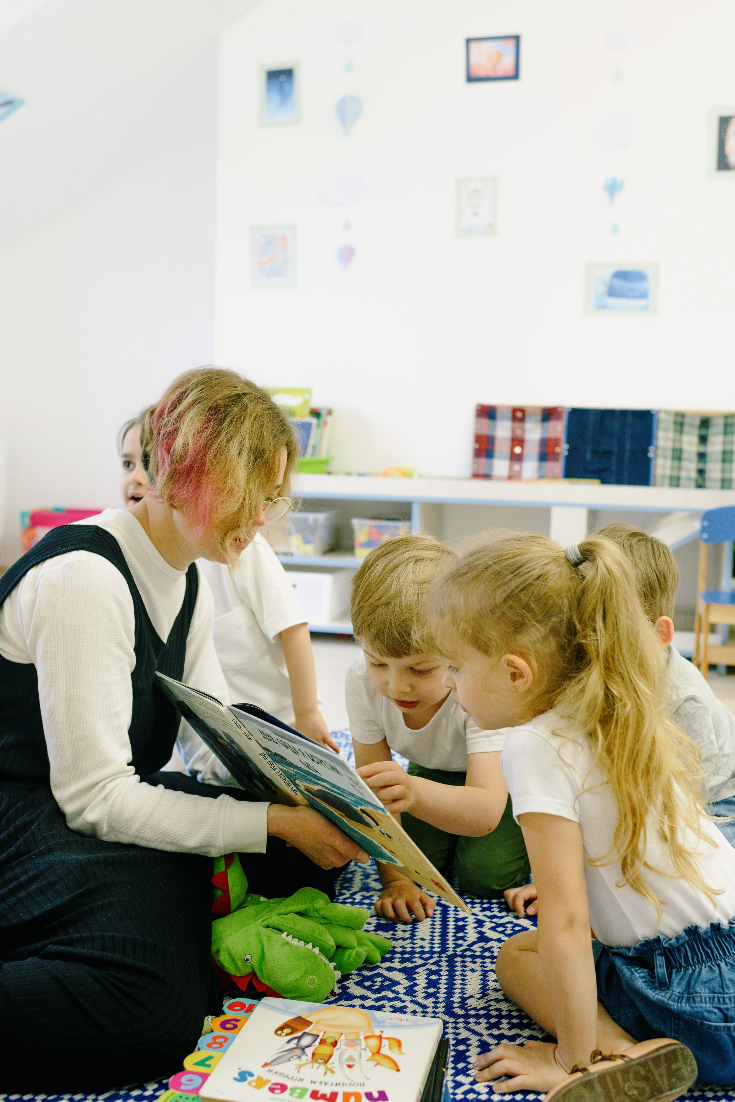 Illustrative photo: A teacher reading to a small group of children