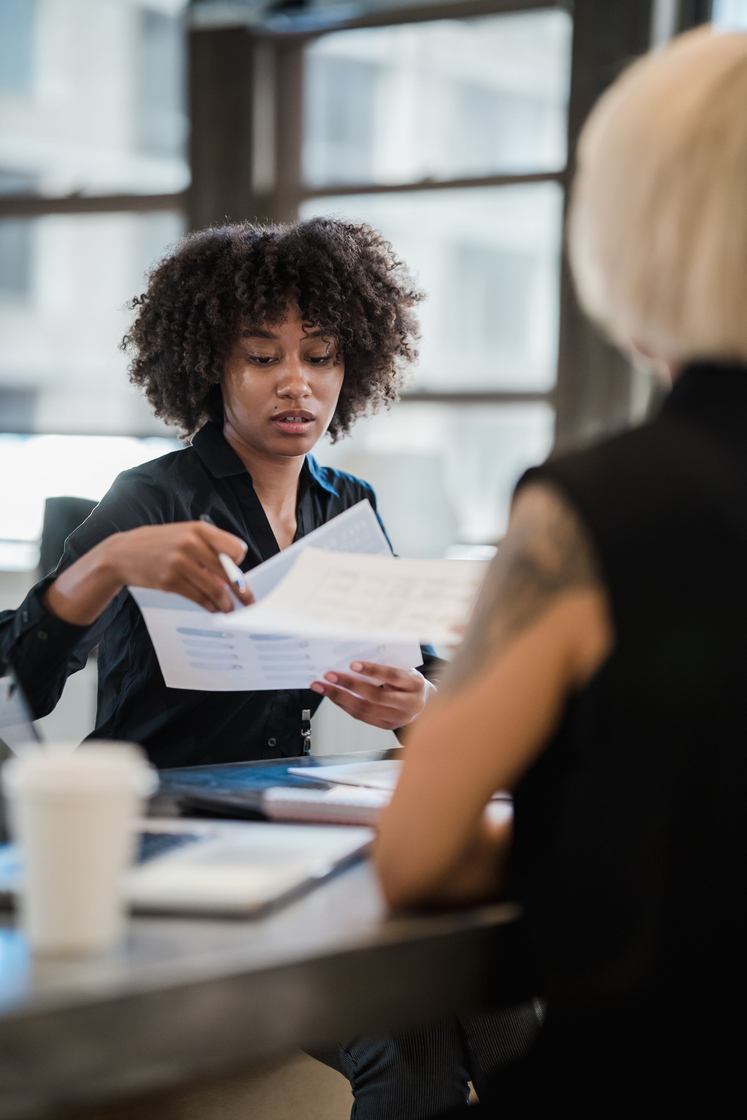 Illustrative photo: A woman reviewing documents at a meeting
