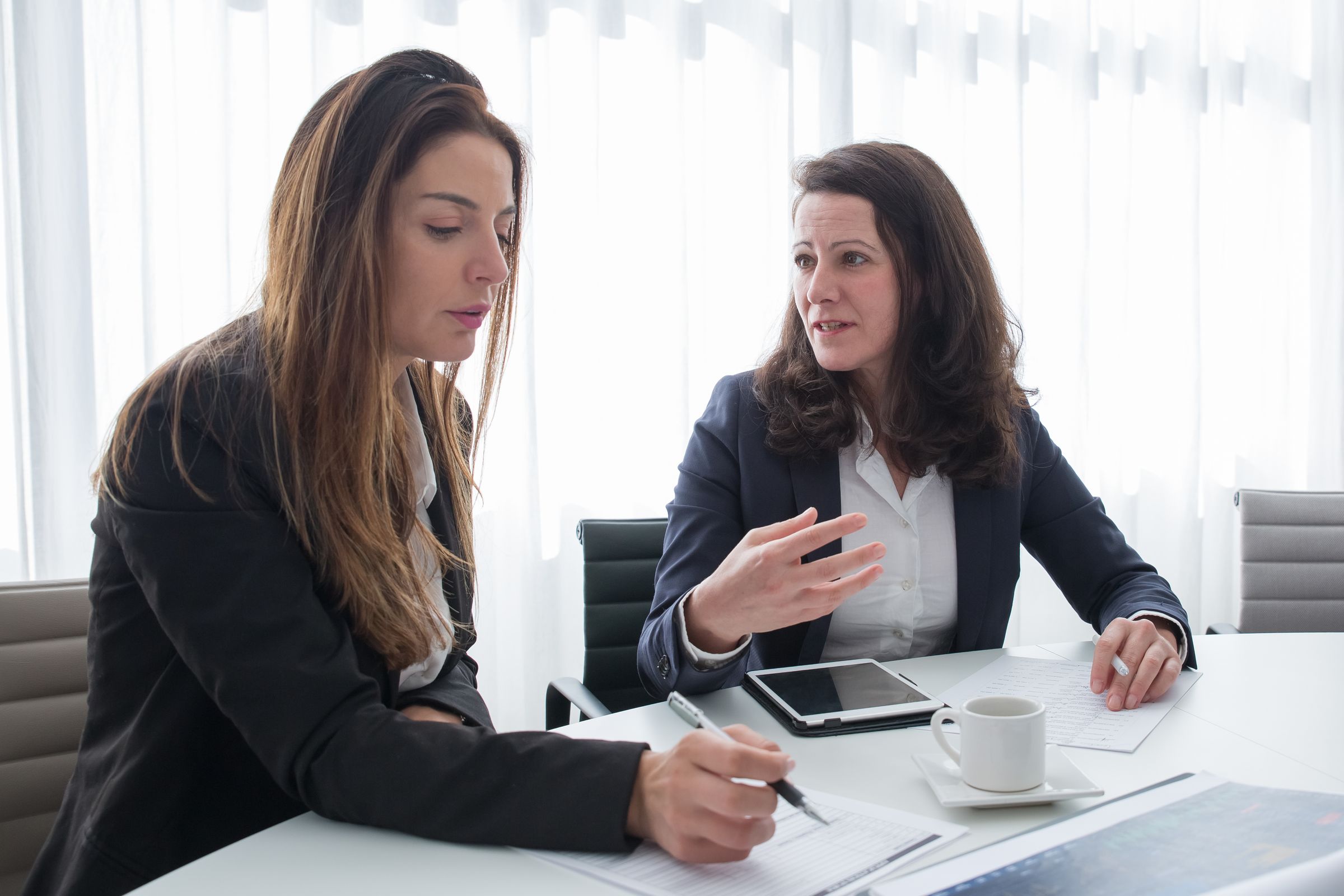 Illustrative photo: Two colleagues discussing their notes