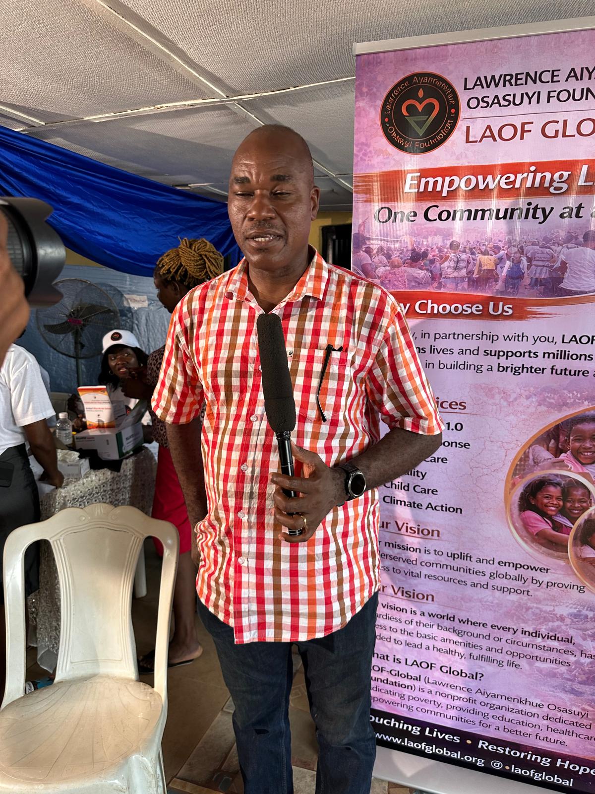A community representative speaking beside a LAOF banner