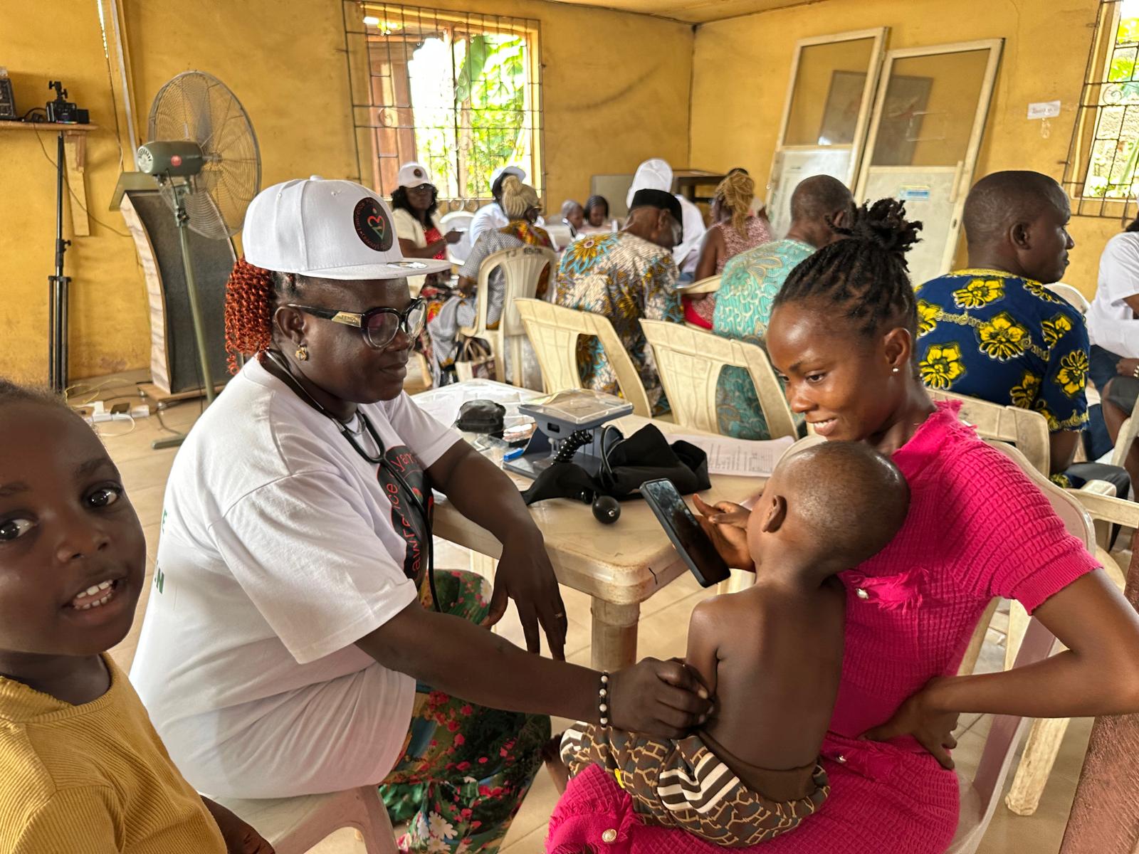 A LAOF volunteer attending to a young child during health outreach
