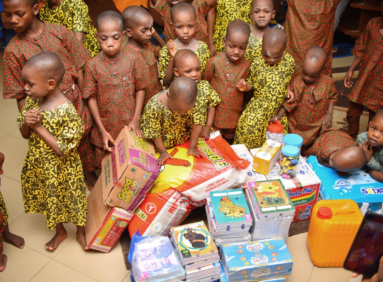 Children gathered around donated learning and household supplies