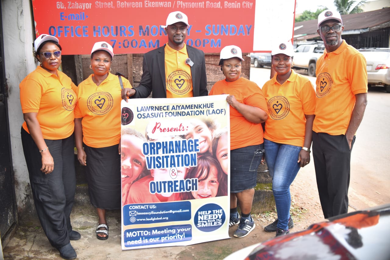 LAOF volunteers standing beside an orphanage visitation outreach banner