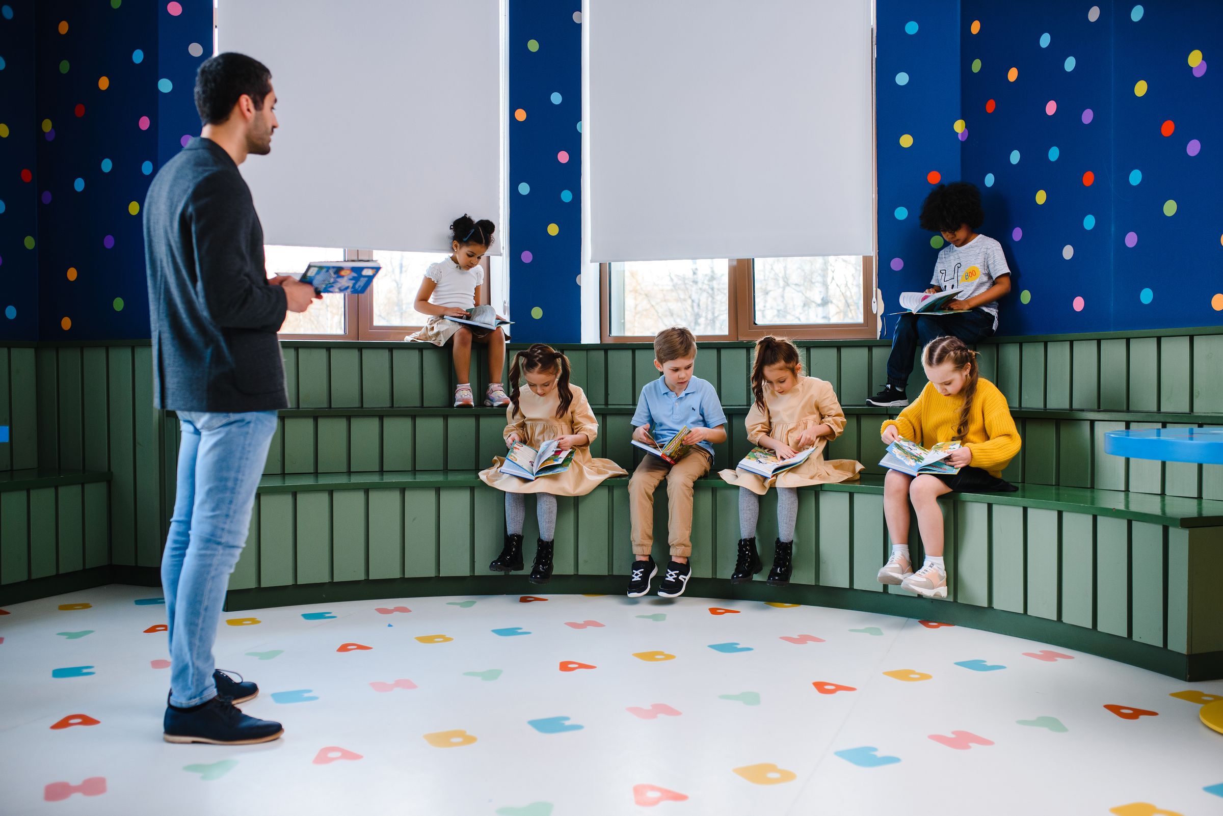 Illustrative photo: Children listening to their teacher in a colourful classroom