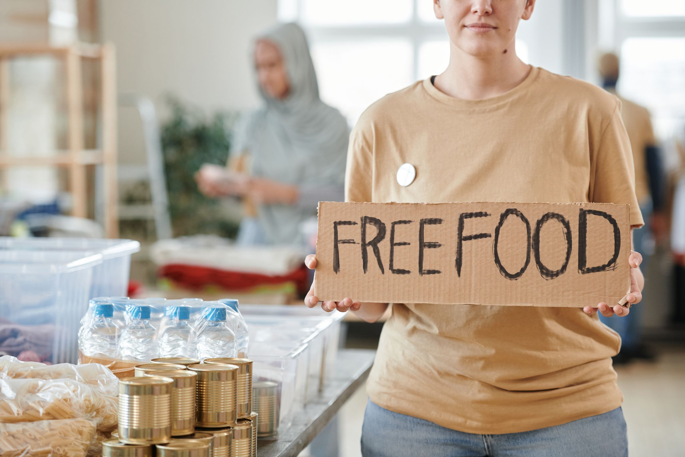 Illustrative photo: A volunteer holding a free food sign