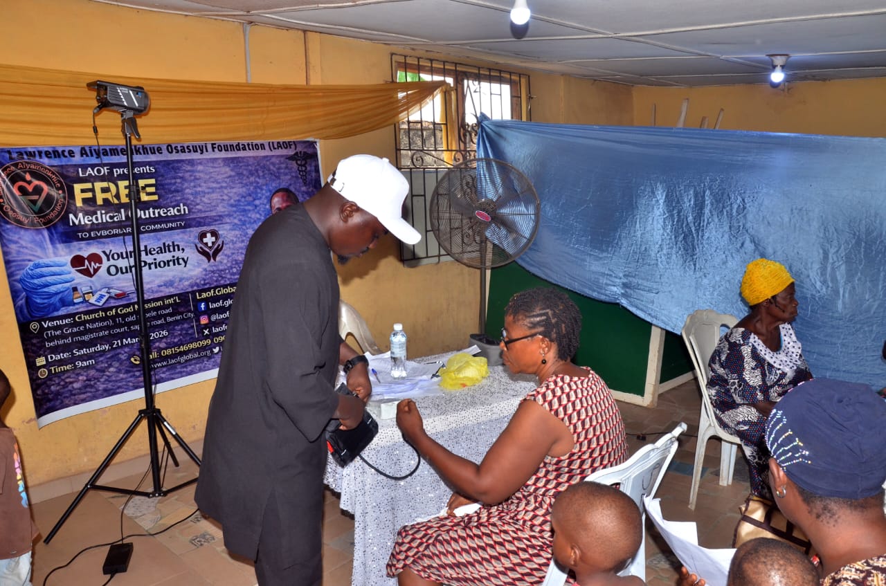 A LAOF health volunteer assisting a seated participant