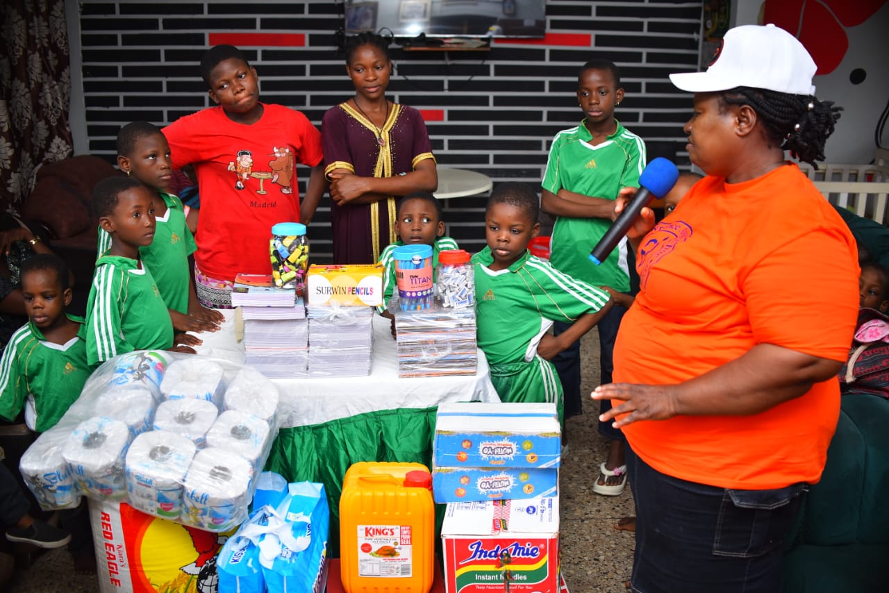 Children listening to a LAOF volunteer beside donated supplies