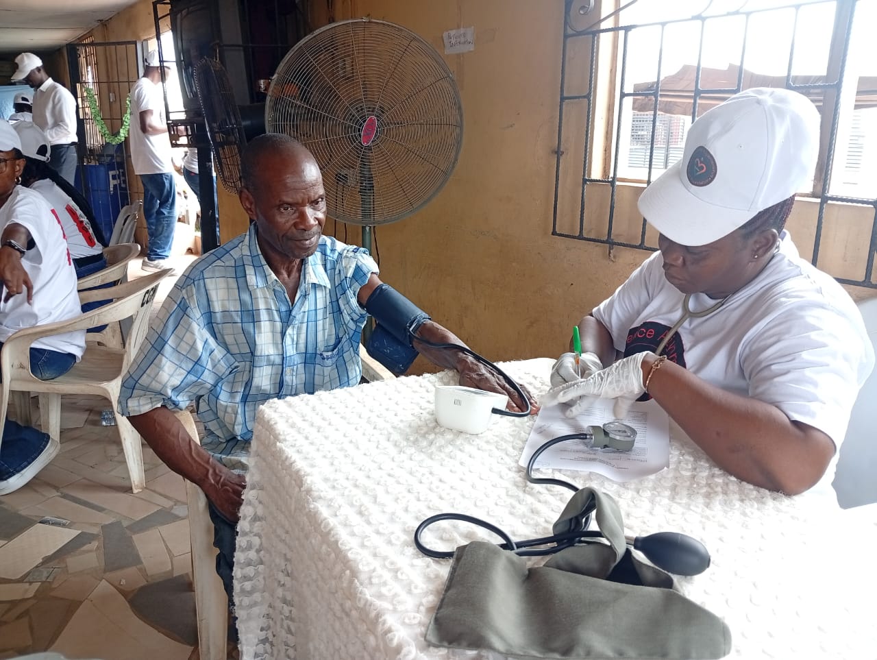 A LAOF volunteer assisting a man during a health consultation