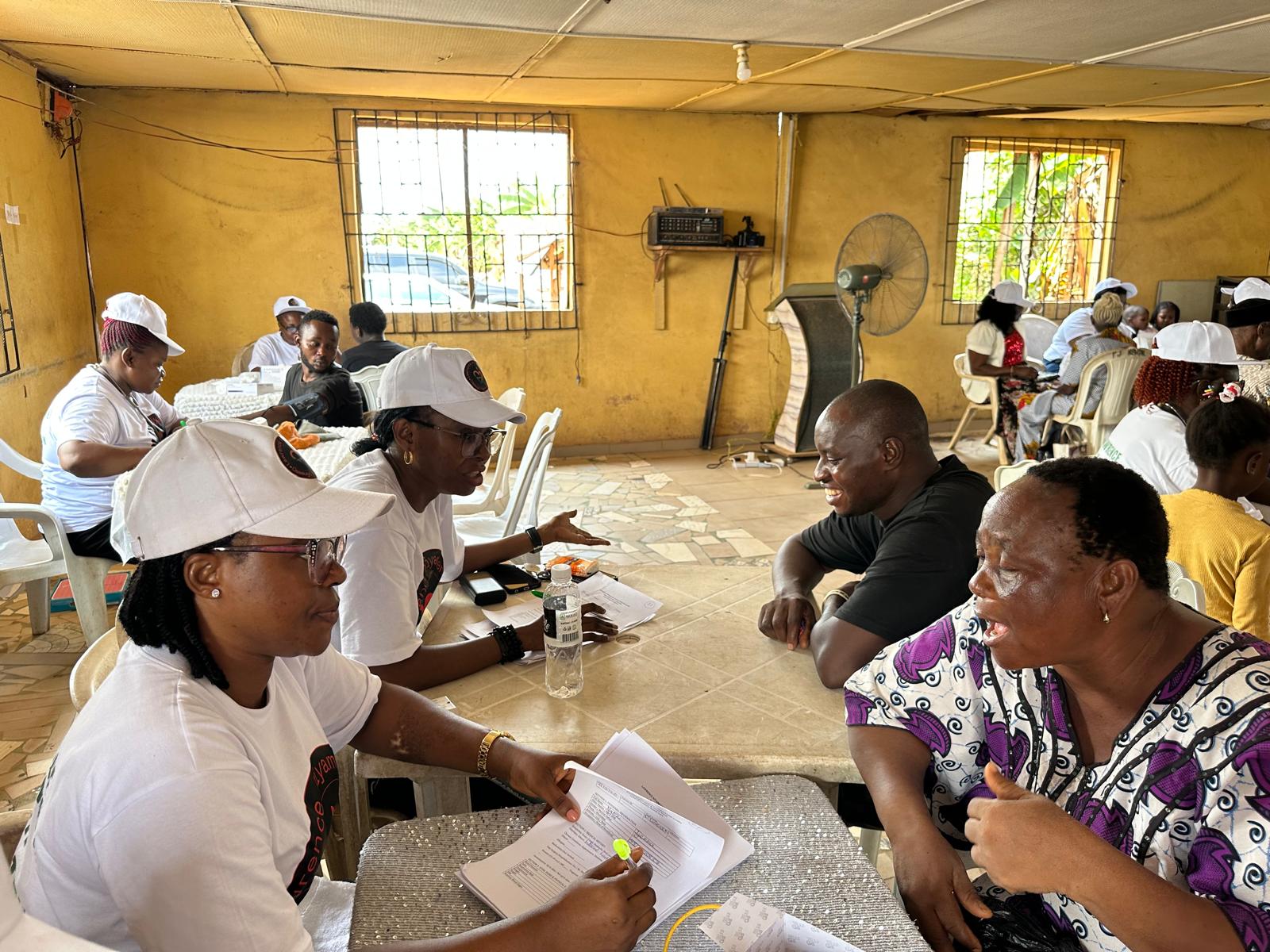Participants receiving support from LAOF volunteers in a community hall