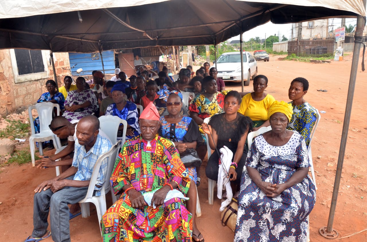 Community participants seated under an outdoor canopy